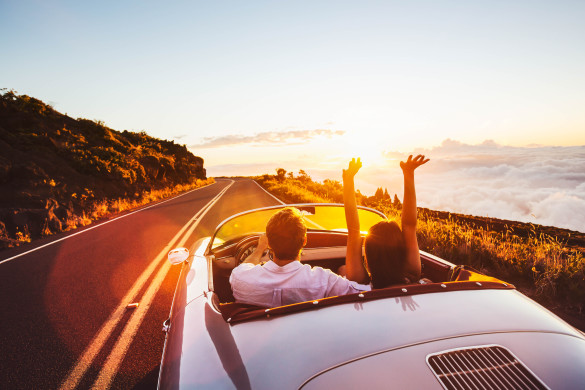 happy-couple-driving-on-country-road-into-the-sunset-in-classic-vintage-sports-car-shutterstock_305567459-2-585x390