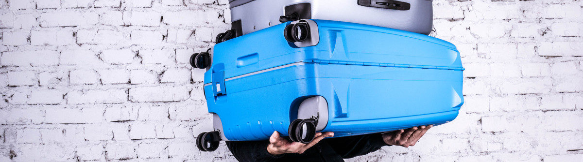 man-holding-three-heavy-suitcases-in-hand-shutterstock_349840742-2-1200×335