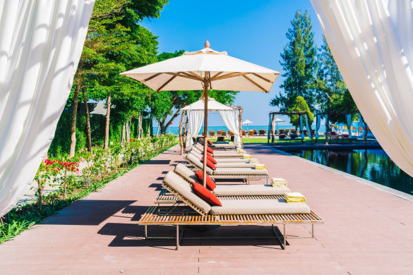 umbrella-pool-and-chair-in-beautiful-luxury-hotel-pool-resort-filter-processing-style-pictures-shutterstock_378577537-2-585x390