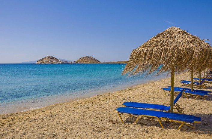sandy-beach-with-umbrellas-and-sunbeds-blue-found-on-any-island-in-greece-and-europe-shutterstock_53945206-2