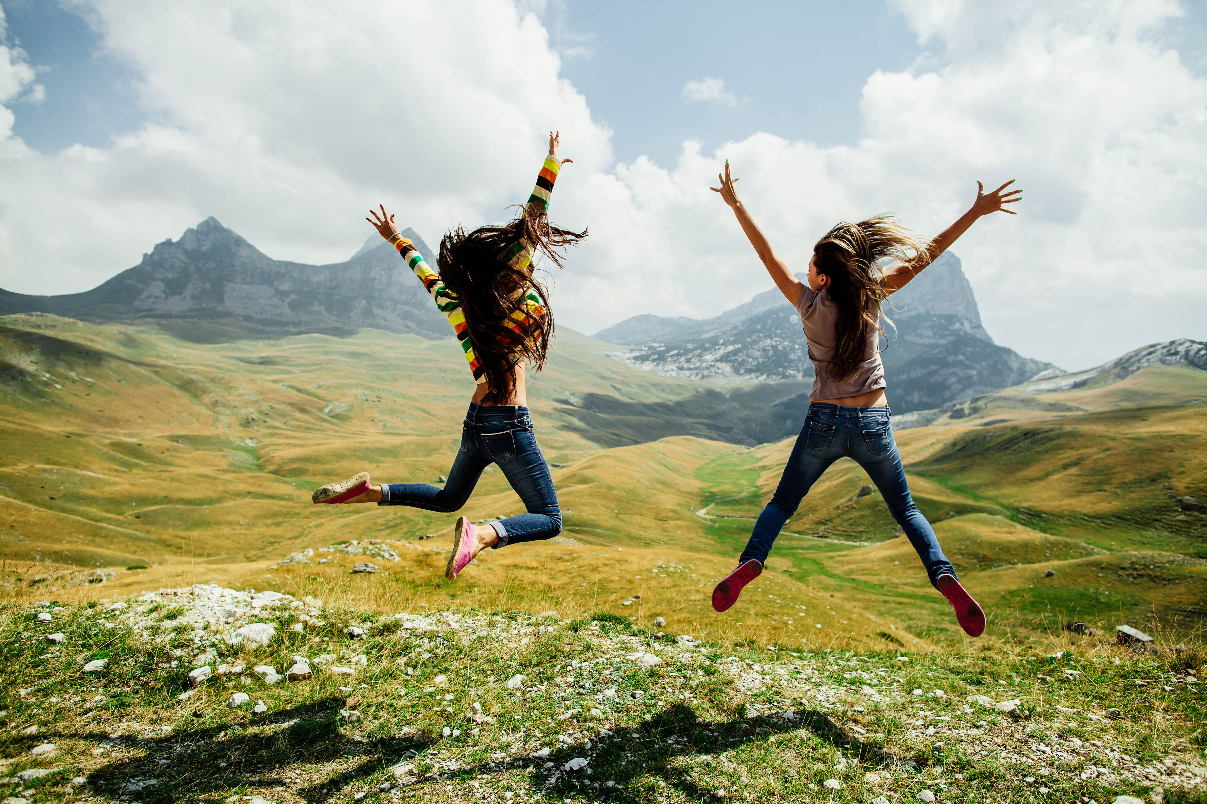 two long hair girls happy jump, World Happiness Report Glücksbericht Glücklichsein 