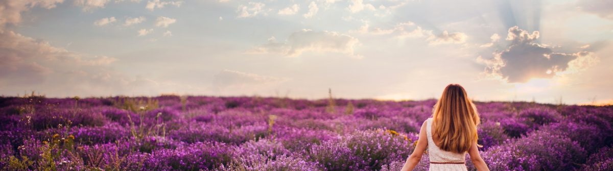 Eine Frau läuft durch ein Lavendelfeld in der Provence
