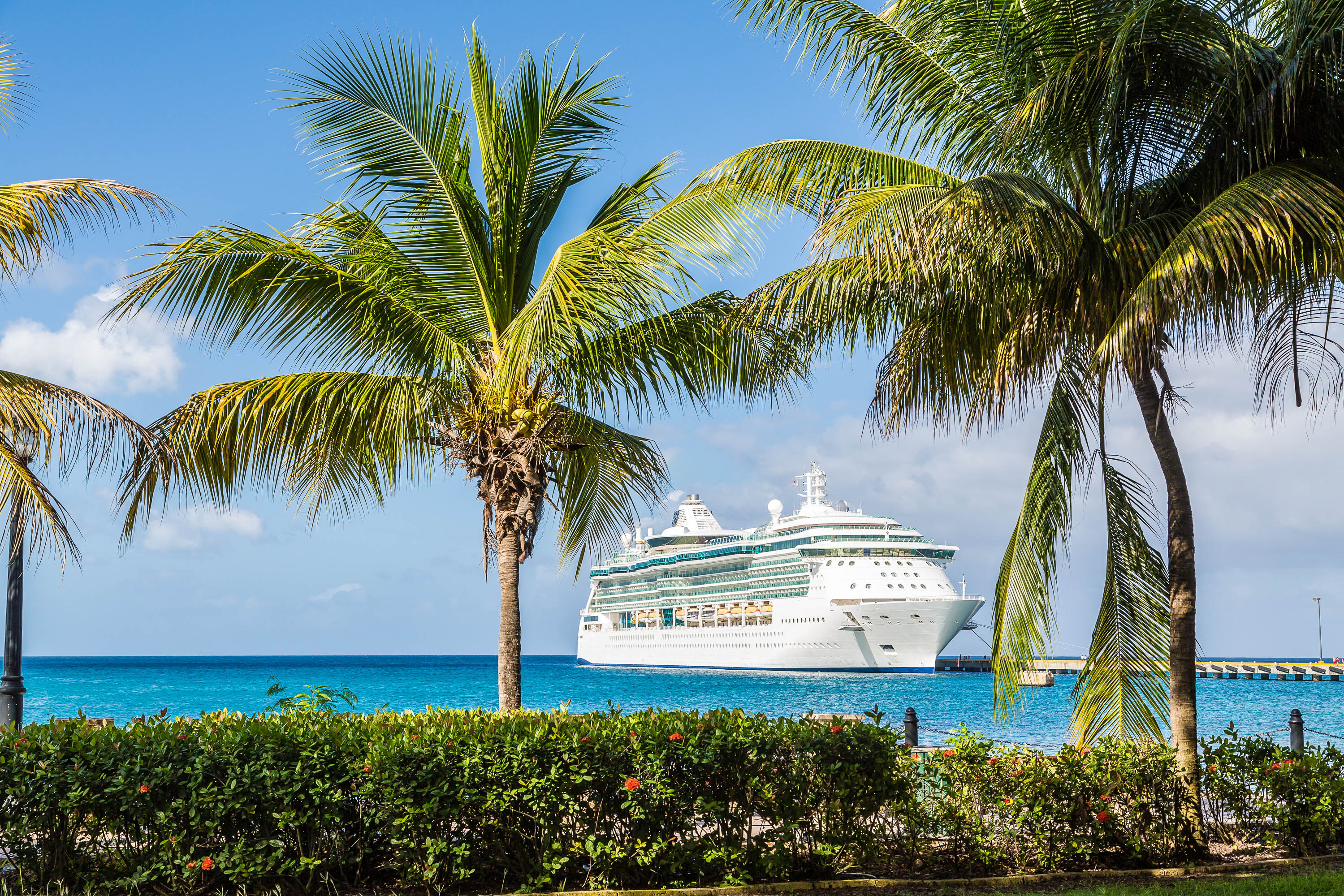 Ein Kreuzfahrtschiff liegt in einem kleinen Hafen in der Karibik vor Anker