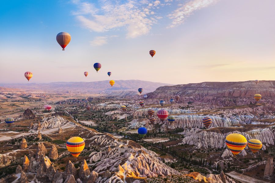 Heißluftballone fliegen über die Landschaft in Kappadokien
