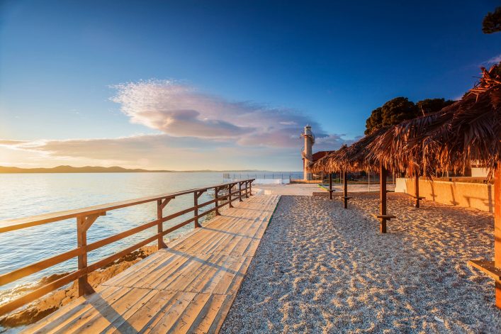 Wooden walkway leading to a lighthouse in Zadar, Croatia