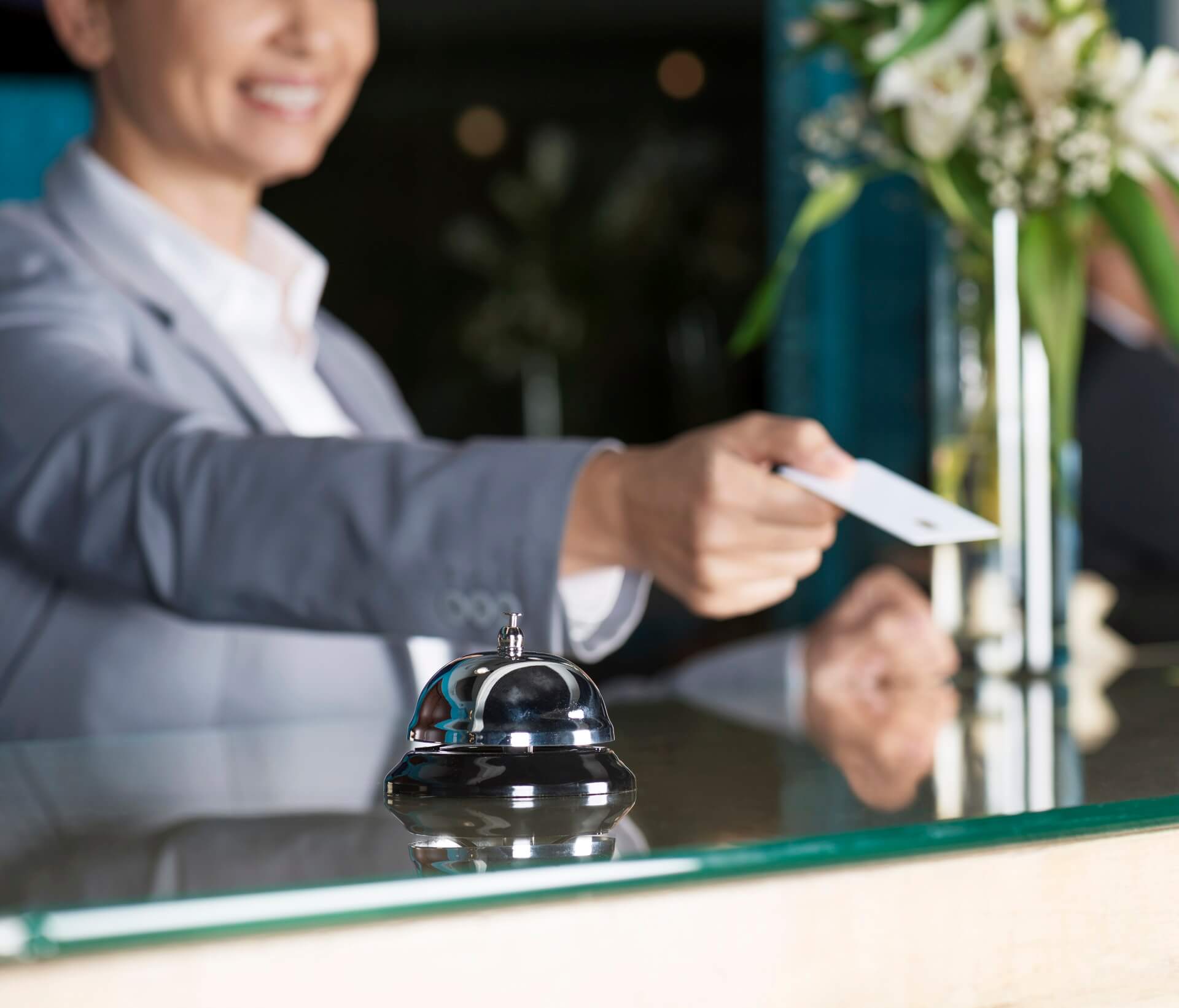 Frau übergibt Karte an der Hotelrezeption