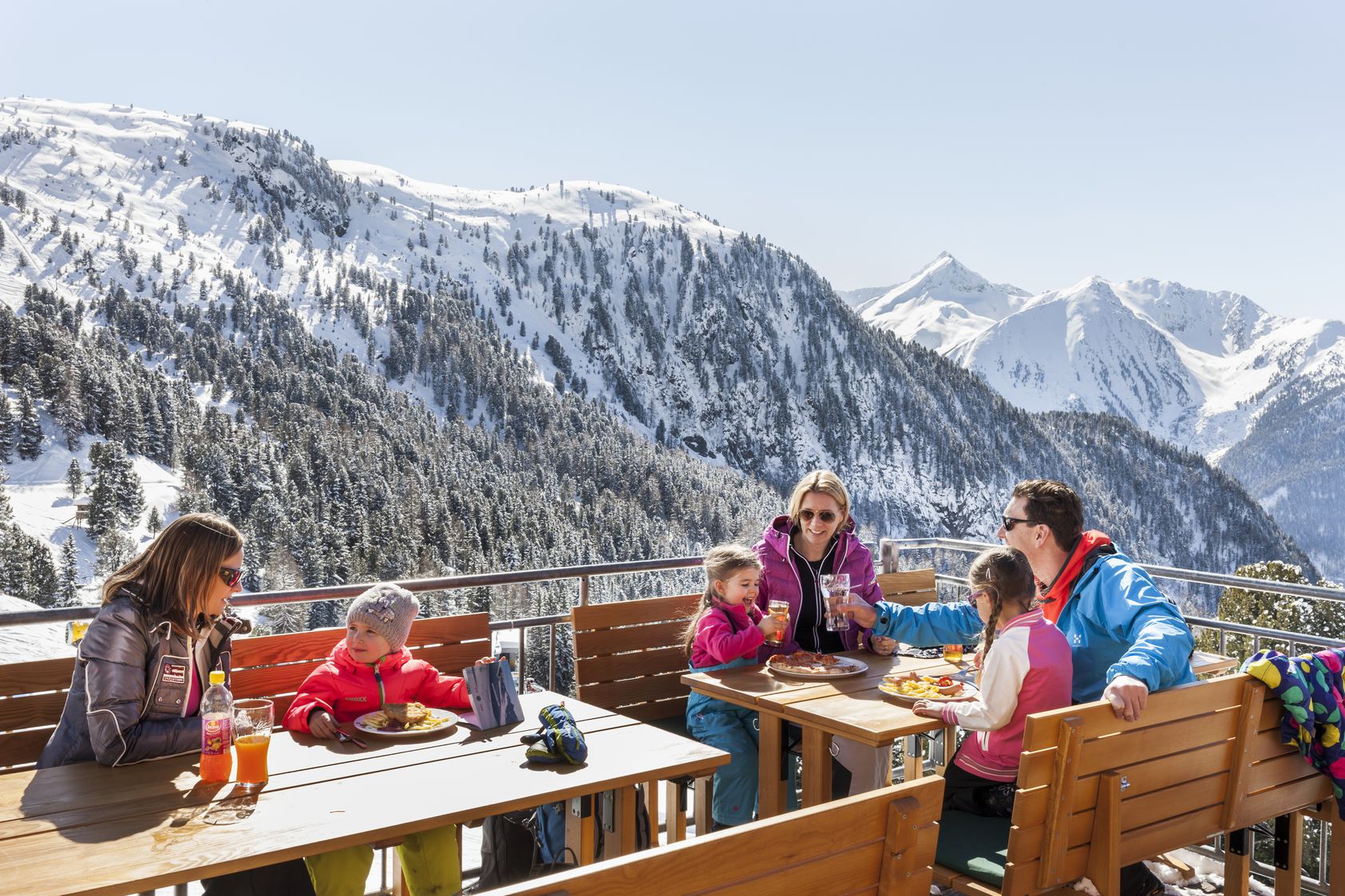 Familie isst im Restaurant auf der Alm am Hochzeiger in Tirol.
