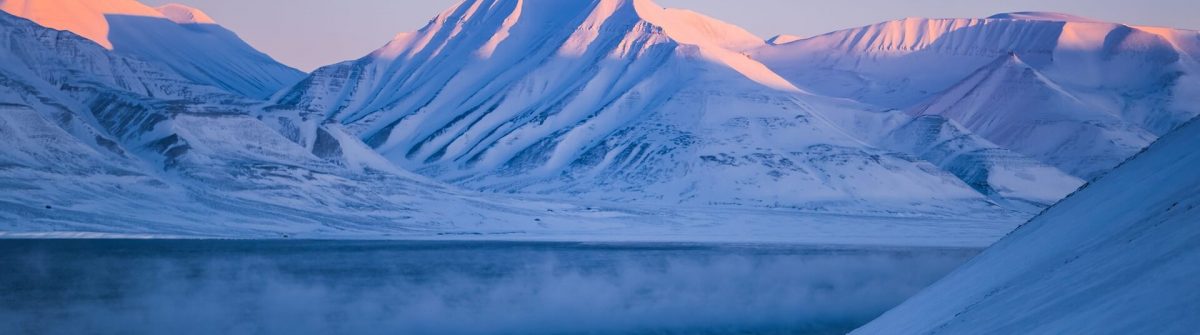 Wintergebirgswelt-Svalbard-Longyearbyen-Svalbard-Norwegen-mit-blauem-Himmel-und-schneebedeckten-Gipfeln-auf-sonnigen-Tagestapeten-bei-Sonnenuntergang-orangefarbenem-Feuer_shutterstock_605660774